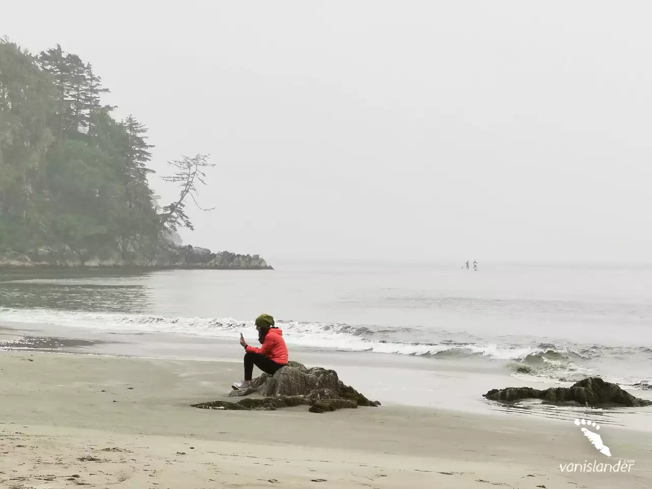 A woman sitting on the beach in Tofino,  Vancouver Island